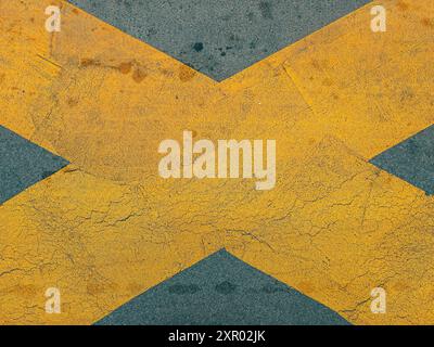 Yellow cross X marking on dark asphalt road surface, top view Stock Photo