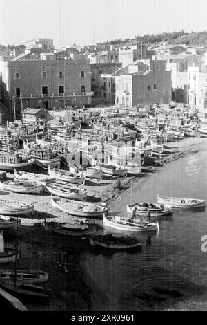 Fischerboote liegen dicht beieinander am Strand von L'Escala, Katalonien 1957. Fishing boats lie close together on the beach at L'Escala, Catalonia 1957. Stock Photo