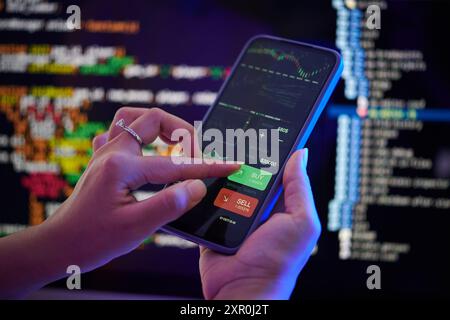 Analyzing Stock Market Trends on Smartphone Screen Stock Photo