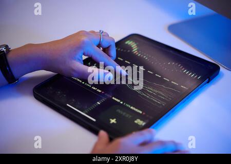 Analyzing Financial Data Using Tablet with Interactive Graphs Stock Photo