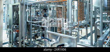 Modern brewery with extensive stainless steel piping and tanks, sophisticated technology used in beer production. Stock Photo