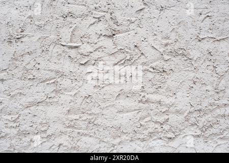 Rough plaster on the wall. The texture of sandy plaster on the facade. Stock Photo