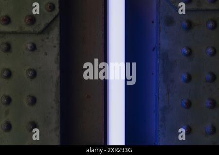 Background texture, iron wall with metal rivets and purple lamp, street photo. Stock Photo