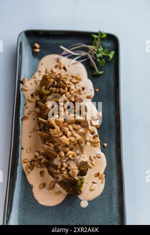 Stewed meat in mushroom sauce and herbs on a ceramic plate Stock Photo