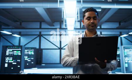 System administrator in data center managing servers, operating systems and software applications. Expert in server hub ensuring networks are secure, up to date, and functioning properly, camera B Stock Photo