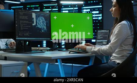 Technician doing checkup on green screen server hub PC to optimize it for data processing requirements of AI. Worker inspects data center used for machine learning using mockup computer, camera A Stock Photo