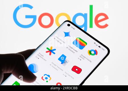 Close-up of a smartphone screen displaying various Google apps with Google logo in the background, showcasing the range of applications developed by G Stock Photo