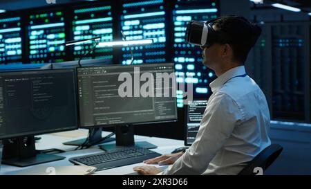 Data center admin responsible for installation of networking systems wearing high tech VR headset. IT worker doing maintenance on server farm gear using virtual reality technology, camera A Stock Photo