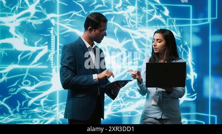 Software developers use neural networks modeled after human brain to solve complex problems. IT specialists in high tech workspace using artificial intelligence to look at data Stock Photo