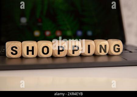 Shopping written on a wooden cube in a office desk Stock Photo