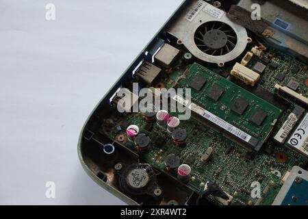 Terengganu, Malaysia - 24 August 2024 : Closeup of teardown an old laptop on isolated background. Laptop component such as hard disk and fan cooler. Stock Photo