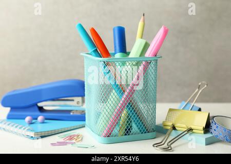 Stapler, holder and other different stationery on white table Stock Photo
