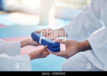 Karate, hands and student with blue belt for learning, training and taekwondo promotion closeup. Martial arts, teacher and people in class for reward Stock Photo