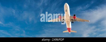 Aeroplane flying isolated on a blue sky background Stock Photo