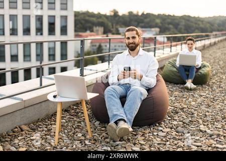 Two professionals working remotely on modern rooftop Stock Photo