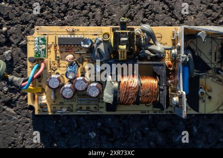 broken electronics board on asphalt outdoors in sunlight Stock Photo