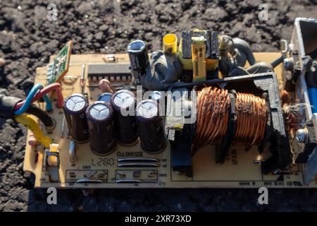 broken electronics board on asphalt outdoors in sunlight Stock Photo