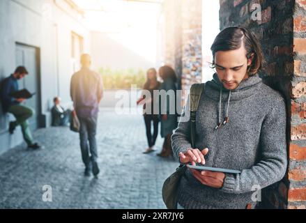 University student, man and scroll tablet on campus for education research, academic learning or online study. Gen z, person or digital tech outdoor Stock Photo