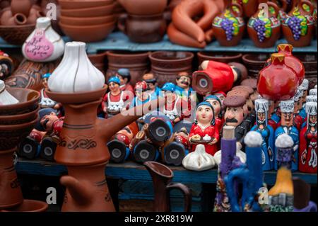 Mtskheta, Georgia - October 10, 2023: Vibrant handmade pottery and figurines displayed at a bustling market in the afternoon. Stock Photo