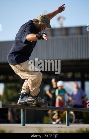 In-line skater doing trick in a skatepark. Roller blader performing a ...