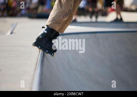 Roller blader grinding on rail in skatepark. Inline skater performing ...