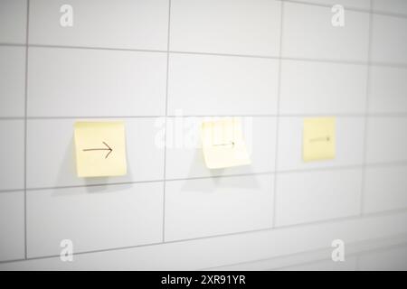 Three post-it yellow sticky notes with arrows pointing right on Stock Photo