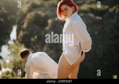 Red-haired woman in a white shirt outdoors with a friend on a sunny day Stock Photo