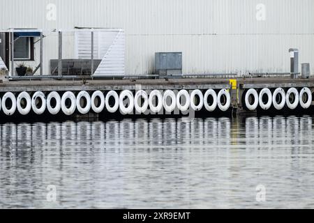 Long row of white painted tyres on a pier Stock Photo