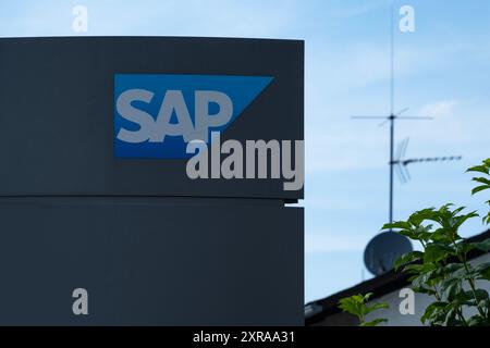 SAP SE logo prominently displayed on modern corporate headquarters facade, SAP corporate campus, symbolizing global software industry leadership, Wall Stock Photo