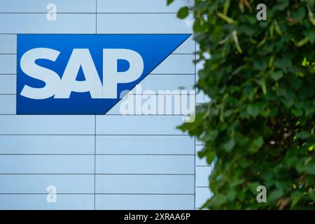 SAP SE logo prominently displayed on modern corporate headquarters facade, SAP corporate campus, symbolizing global software industry leadership, Wall Stock Photo