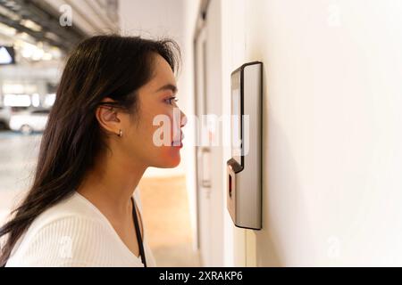 Futuristic and technological scanning of the face of a beautiful business woman for facial recognition can serve to ensure personal safety in the work Stock Photo