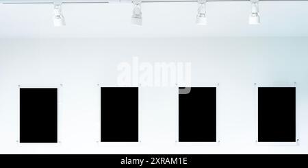 A row of black frames hang from a white wall. The frames are all different sizes and shapes, clipping path. They are all lined up in a row and they cr Stock Photo