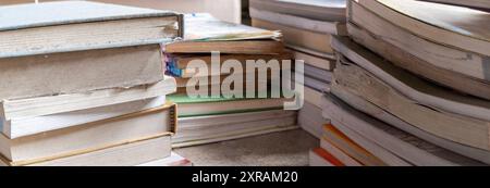 A stack of books in a variety of colors and sizes with different covers and titles. A collection of books in a bookstore. A stack of books in a study. Stock Photo