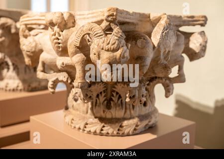 Close-up on sculptures of animals carved in medieval pillar base in ruins Stock Photo