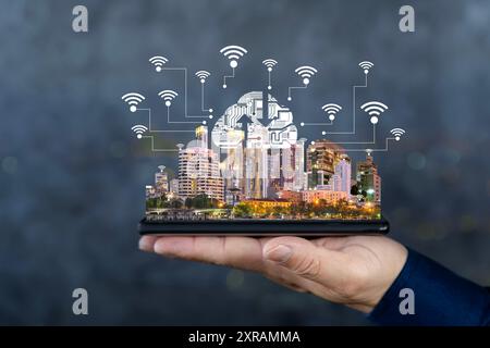 Smart City and Internet of Things (IOT) on smartphone in hand, object icons connected together, internet network concept with blurred modern city back Stock Photo