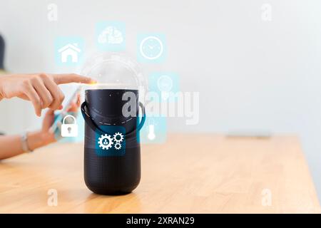 Woman turns on smart speaker with active artificial intelligence assistant with futuristic screenless interface with different icons and symbols. Home Stock Photo