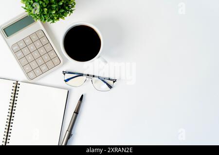 Work desk. Work desk. Top view of work space with calculator, pens, laptop on white background, copy space for blank text for quotes, finance, busines Stock Photo