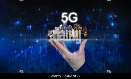 Creative background, male hand holding a phone with 5G hologram on city background. Concept of 5G network, mobile high speed internet, new generation Stock Photo