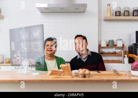 Happy senior old couple using laptop computer holding credit card ordering food delivery in grocery e store supermarket doing ecommerce shopping, buyi Stock Photo
