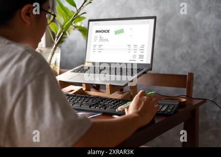 Accountant Using E Invoice Software At Computer In Office. Online digital e-invoicing and statement software. Financial accounting concepts, online ta Stock Photo