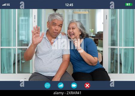 Application screenshot view of happy mature grandparents sitting at home having video call with relatives, smiling old man and woman chatting online u Stock Photo