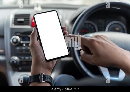 Mockup of man driver hand using blank white screen mobile smart phone inside a car, searching location via gps navigator application, close up. Mockup Stock Photo
