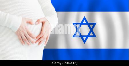 Pregnant woman making heart against her stomach on Israeli flag background. Demographics, pregnancy and love baby in Israel concept. Stock Photo