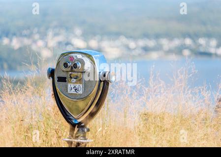 Close up of coin operated tourist binoculars on a mountaintop overlooking a river valley on a sunny autumn day. Copy Space and bokeh. Stock Photo