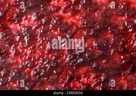 Background with forest fruit jam spread on a white base. Top view. Stock Photo