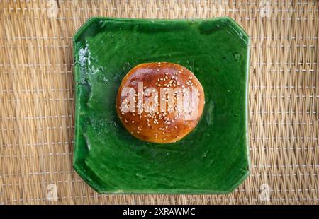 Moroccan Krachel bun, sweet bread with Aniseed (anise) Sesame Seeds, brioche bun, on a traditional handmade green plate, top view, Marrakech, Morocco Stock Photo