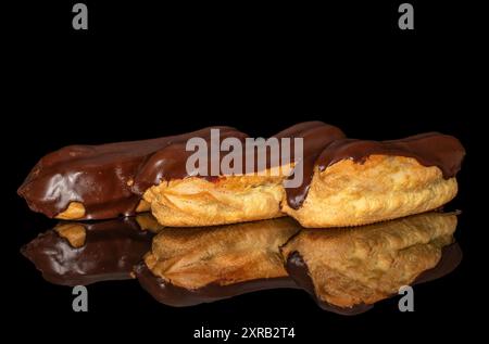 Three eclairs with cream, macro, isolated on a black background. Stock Photo