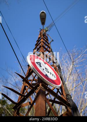 Red traffic sign on an old, rusty lamp post, sunny day in winter, blue sky Stock Photo