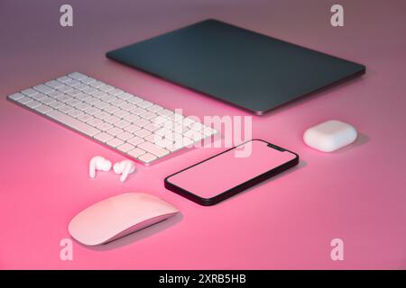 Home office electronic devices on pink background. Isometric view. Smartphone empty screen mockup. Stock Photo