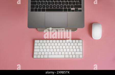Laptop keyboard from above. Clean empty peach colour background. Stock Photo